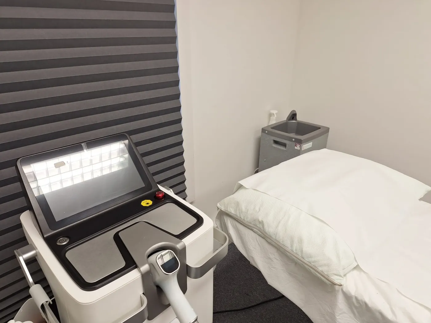 The laser room at Laserlite Clinic — diode laser beside the treatment bed The laser room at Laserlite Clinic — diode laser beside the treatment bed