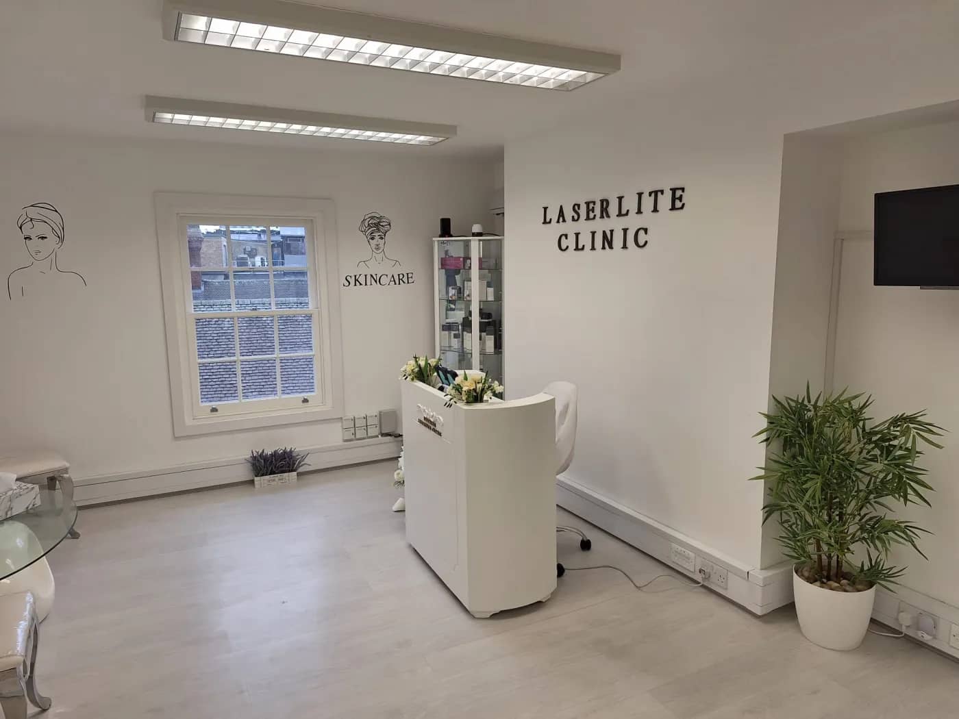The Laserlite Clinic reception on George Street — white desk, product cabinet and clinic lettering The Laserlite Clinic reception on George Street — white desk, product cabinet and clinic lettering