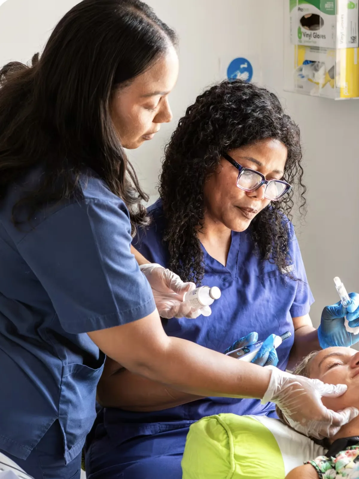 Two Laserlite practitioners with a client during a treatment at the clinic Two Laserlite practitioners with a client during a treatment at the clinic