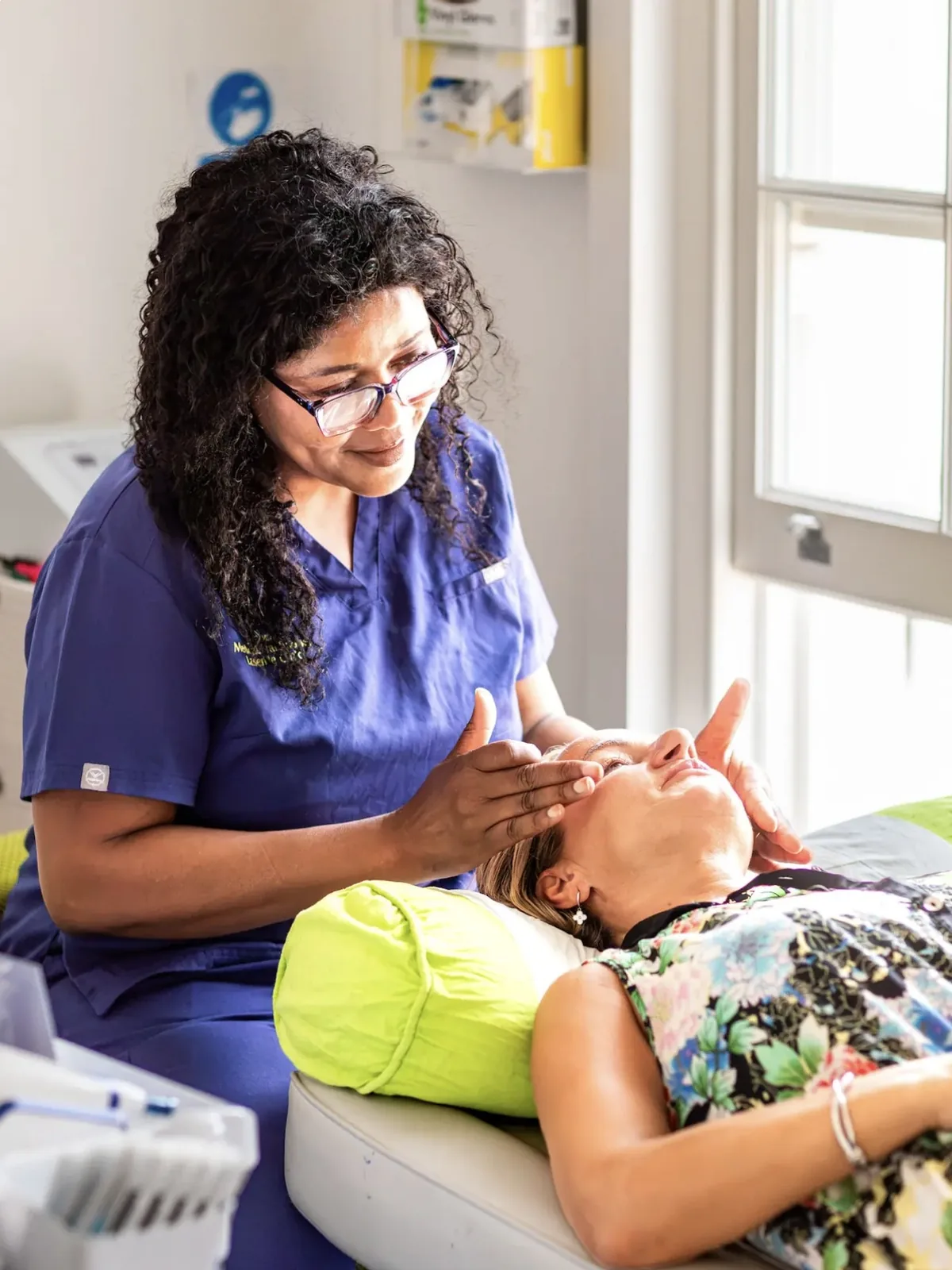 A Laserlite practitioner with a client on the treatment bed, by the window A Laserlite practitioner with a client on the treatment bed, by the window